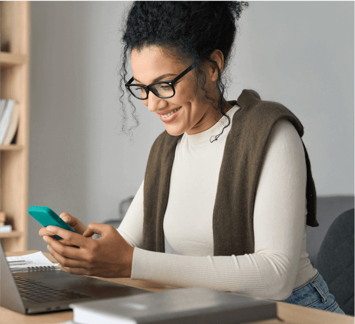 Uma mulher sorridente utilizando um tablet para gerenciar pagamentos.