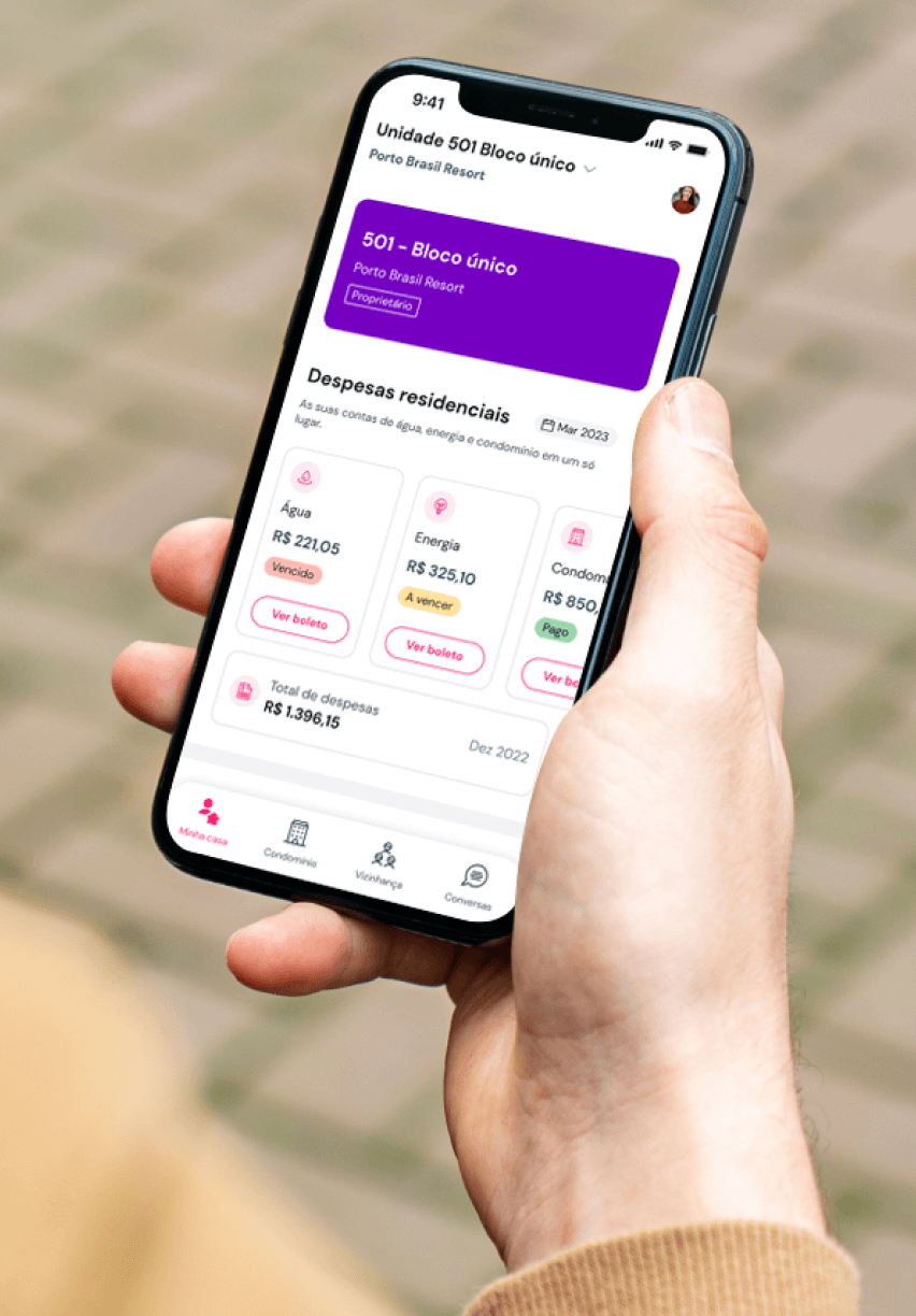 Mão segurando smartphone exibindo a interface do aplicativo Gruvi para moradores, mostrando boletos e avisos do condomínio.