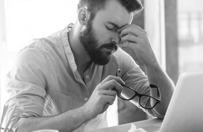 Homem preocupado com monte de pastas
